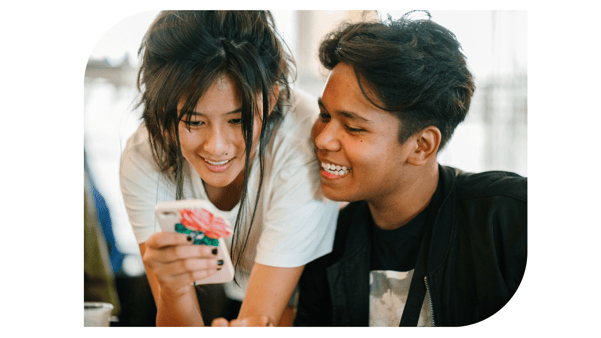 teen male and female looking at phone